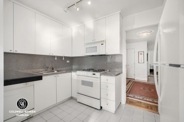 kitchen with light tile patterned floors, sink, white appliances, and white cabinets