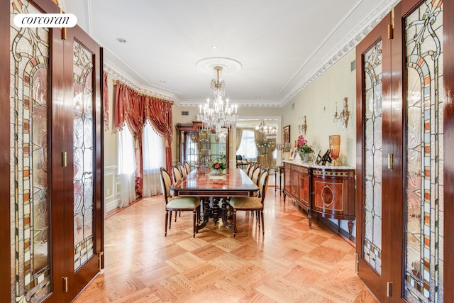 dining room with an inviting chandelier, ornamental molding, and french doors