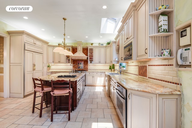 kitchen with cream cabinetry, visible vents, custom exhaust hood, and open shelves