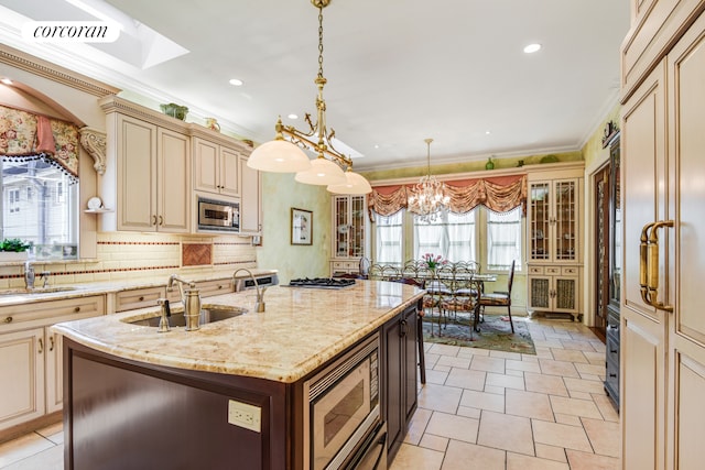 kitchen with tasteful backsplash, cream cabinets, stainless steel appliances, crown molding, and a sink