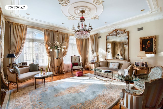 sitting room featuring an inviting chandelier, visible vents, and crown molding