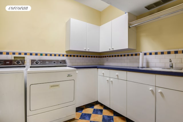 laundry room featuring visible vents, cabinet space, a sink, and separate washer and dryer