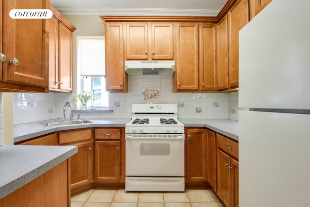 kitchen featuring under cabinet range hood, white appliances, a sink, ornamental molding, and tasteful backsplash