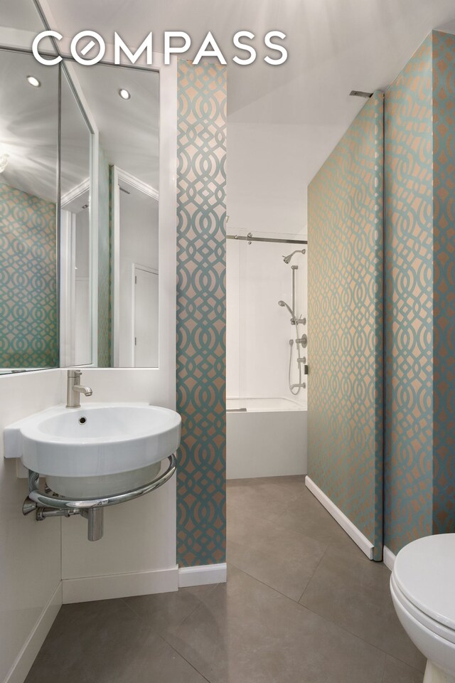 304 E 65th St Unit 38Ad, New York City, NY 10065 - bathroom featuring toilet, shower / tub combination, baseboards, tile patterned floors, and wallpapered walls