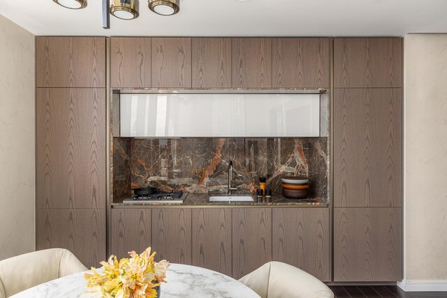 dining room with a tray ceiling, a water view, built in shelves, dark hardwood / wood-style flooring, and a chandelier