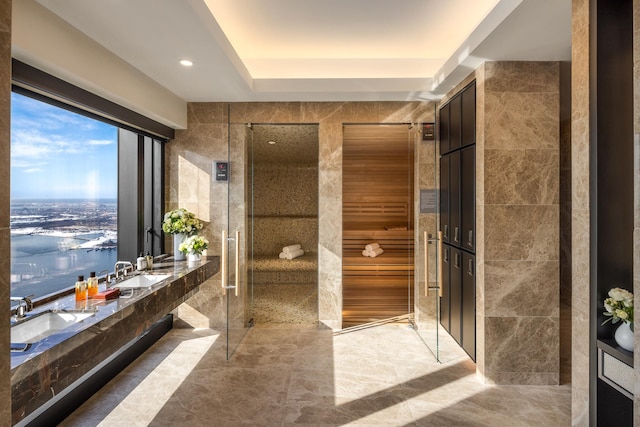 125 Greenwich St Unit 38B, New York City, NY 10006 - bathroom with tile walls, a sink, a shower, and recessed lighting