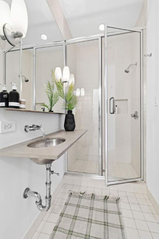 bathroom with tile patterned flooring, sink, and walk in shower