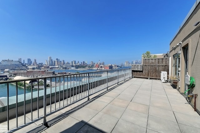 view of patio with a balcony and a water view