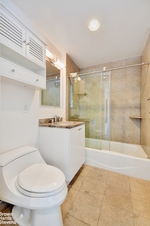 full bathroom featuring toilet, combined bath / shower with glass door, tile patterned flooring, and vanity