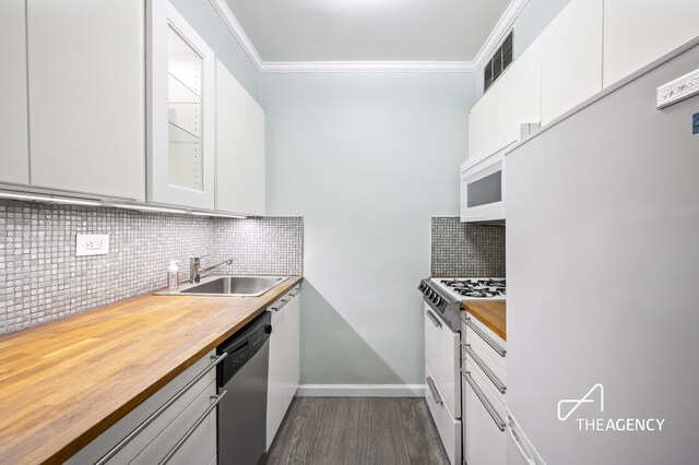 kitchen with sink, white appliances, white cabinets, and tasteful backsplash