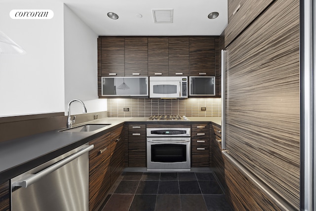 kitchen featuring stainless steel appliances, modern cabinets, a sink, and visible vents