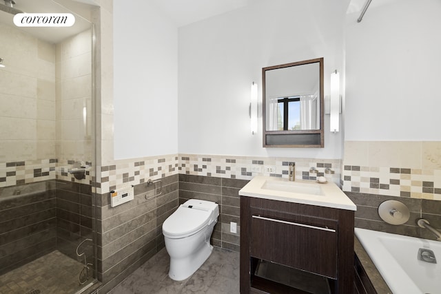 full bath featuring toilet, a bath, vanity, a shower stall, and tile walls