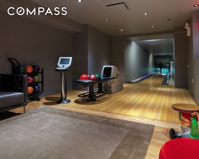 playroom with visible vents, wood finished floors, and a bowling alley