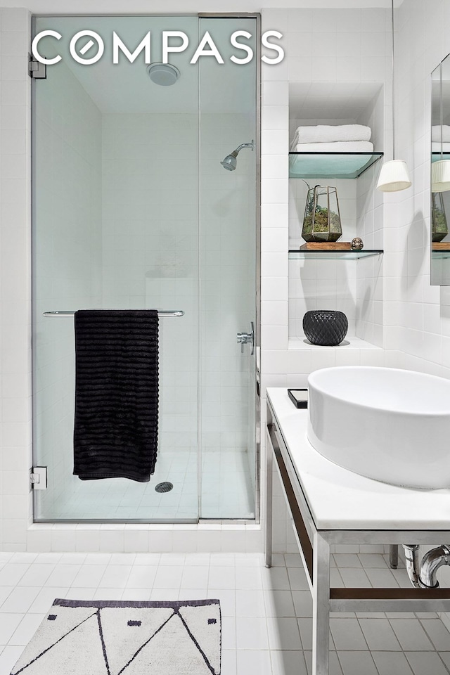 bathroom with backsplash, a stall shower, and tile patterned flooring