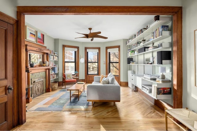 living area with ceiling fan, crown molding, and light parquet floors