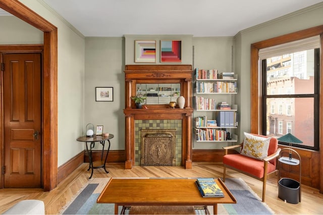 living area featuring hardwood / wood-style floors, crown molding, and a fireplace