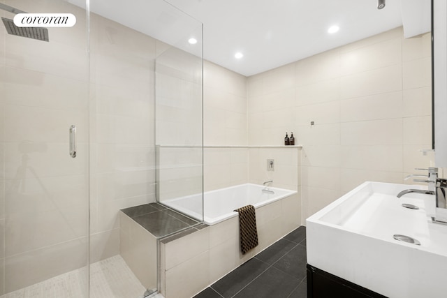 bathroom featuring tile walls, tile patterned floors, a stall shower, vanity, and a bath