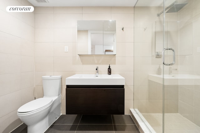 full bathroom featuring tile patterned floors, a shower stall, vanity, and tile walls