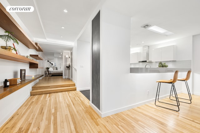 hall featuring baseboards, recessed lighting, visible vents, and light wood-style floors