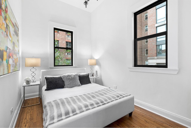 bedroom featuring wood finished floors and baseboards