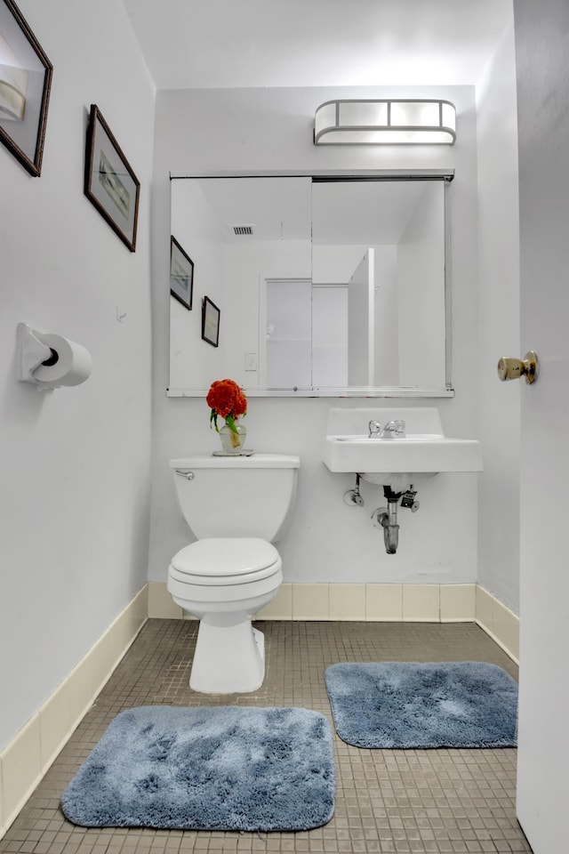 half bathroom featuring toilet, tile patterned floors, and visible vents