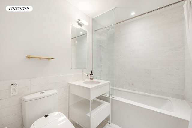 full bath featuring toilet, visible vents, vanity, tile walls, and shower / washtub combination