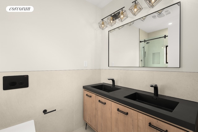 full bathroom with double vanity, an enclosed shower, and a sink