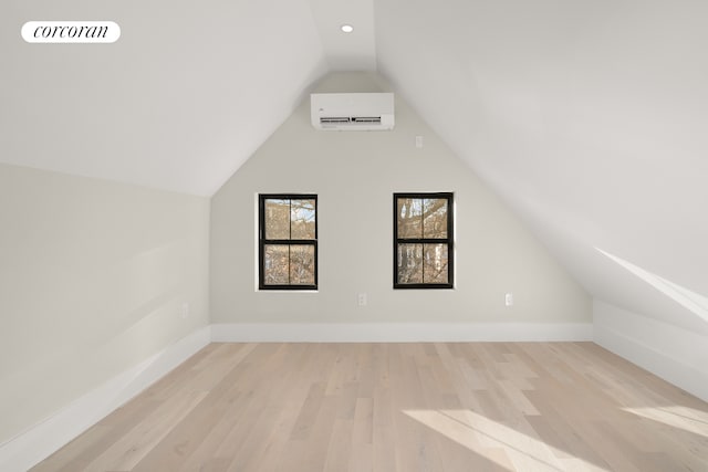 bonus room with visible vents, wood finished floors, a wall unit AC, baseboards, and vaulted ceiling