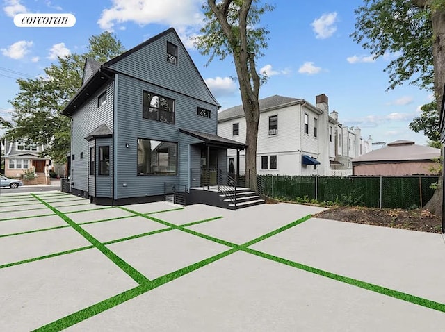 view of front of property featuring a patio area and fence