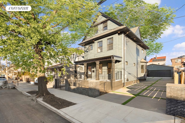 view of front facade featuring a porch, an outbuilding, and a detached garage