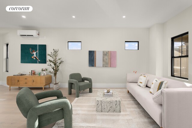 living room featuring an AC wall unit and light wood-type flooring