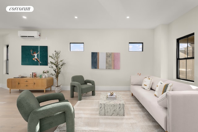 living room with an AC wall unit and light hardwood / wood-style flooring