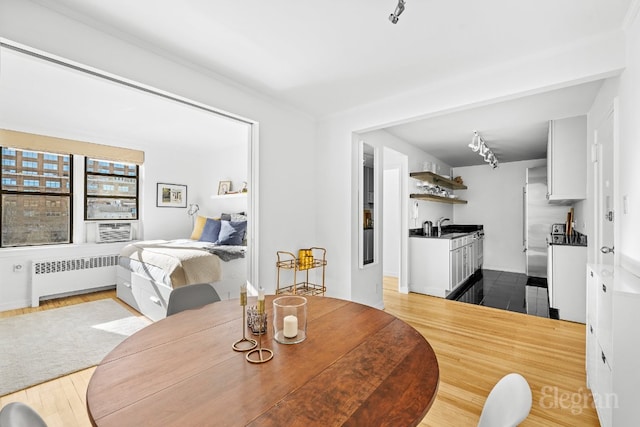 dining area with radiator, sink, and hardwood / wood-style flooring