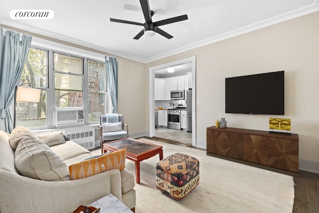 living room featuring radiator, wood-type flooring, cooling unit, ornamental molding, and ceiling fan