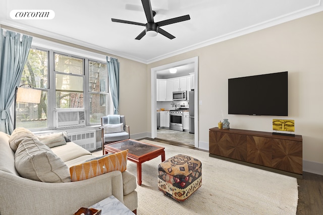 living room with ceiling fan, visible vents, baseboards, ornamental molding, and radiator heating unit