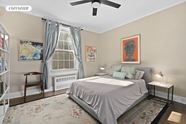 bedroom featuring radiator heating unit, crown molding, visible vents, and wood finished floors