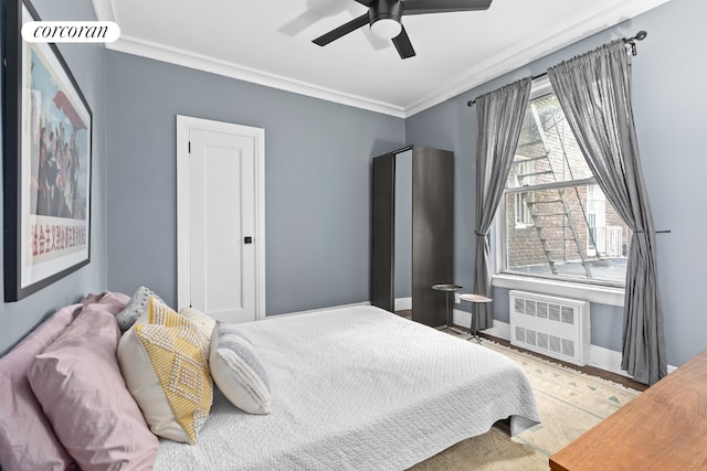 bedroom with ceiling fan, ornamental molding, wood-type flooring, and radiator heating unit