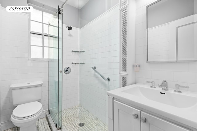 bathroom featuring tile walls, toilet, vanity, and an enclosed shower