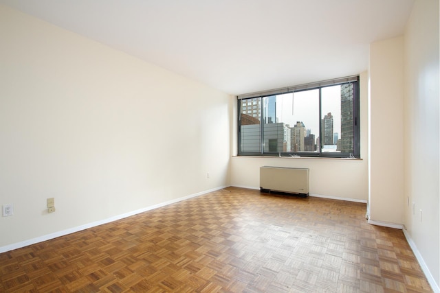 empty room featuring radiator heating unit and baseboards