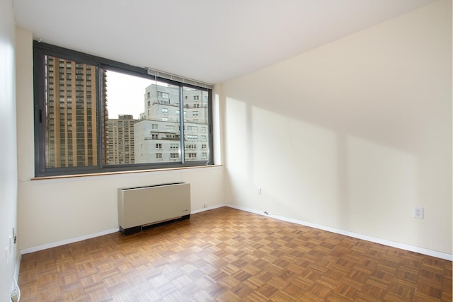 empty room featuring baseboards and radiator heating unit