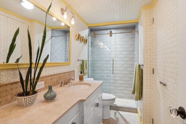 full bath featuring vanity, wallpapered walls, a stall shower, ornamental molding, and toilet