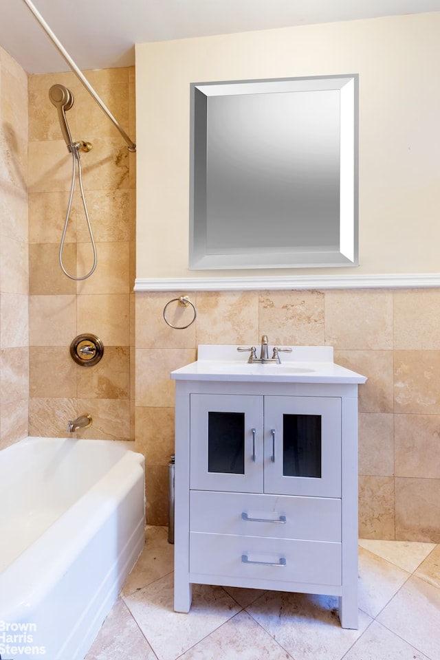 bathroom with washtub / shower combination, wainscoting, vanity, and tile walls