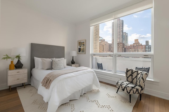 320 E 82nd Street Penthouse, New York City, NY 10028 - bedroom featuring wood finished floors, a skyline view, and baseboards