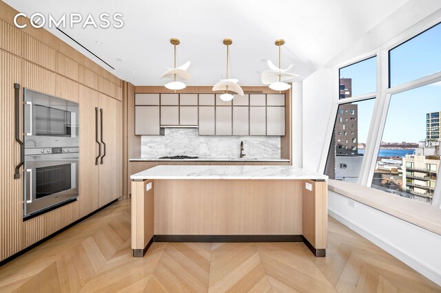 kitchen featuring pendant lighting, a center island, light parquet flooring, and appliances with stainless steel finishes