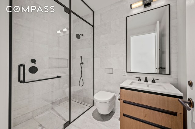 bathroom featuring vanity, a shower with door, tile walls, and toilet