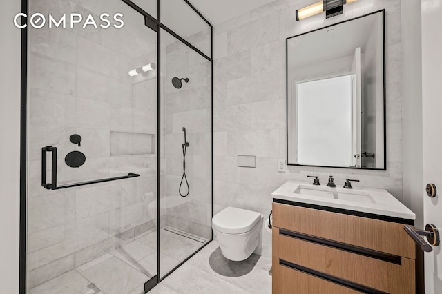 bathroom with tile walls, tiled shower, vanity, and toilet