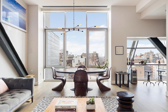 dining space with floor to ceiling windows, a chandelier, and hardwood / wood-style floors