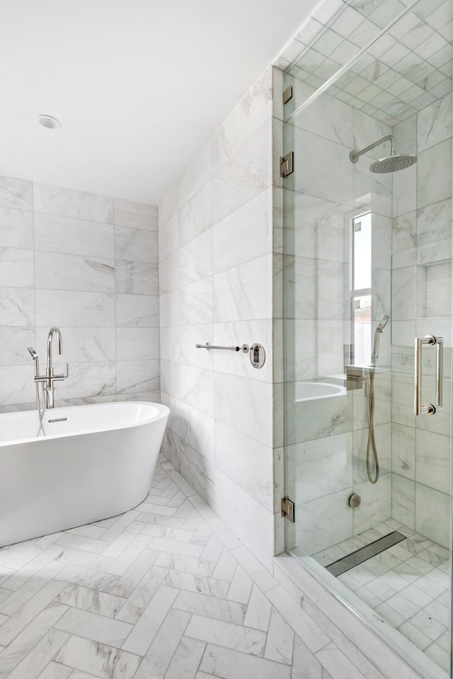 bathroom featuring tile walls, a freestanding bath, and a shower stall