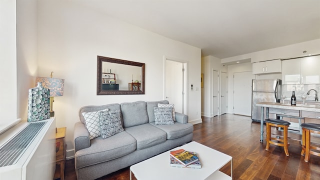 living room featuring dark wood-type flooring and sink