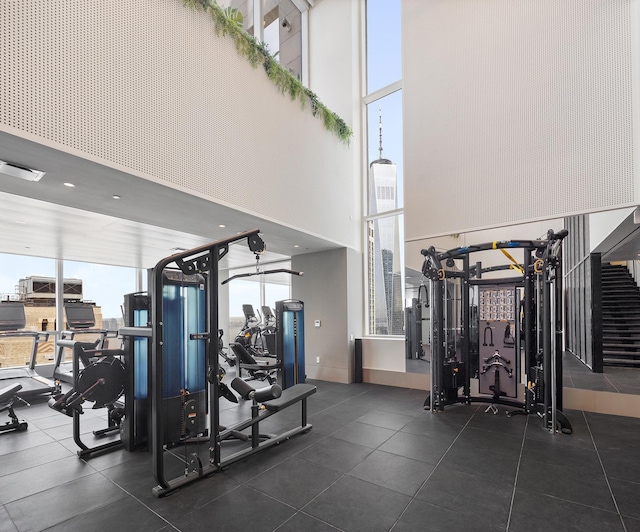 workout area with a wall of windows, a high ceiling, and visible vents